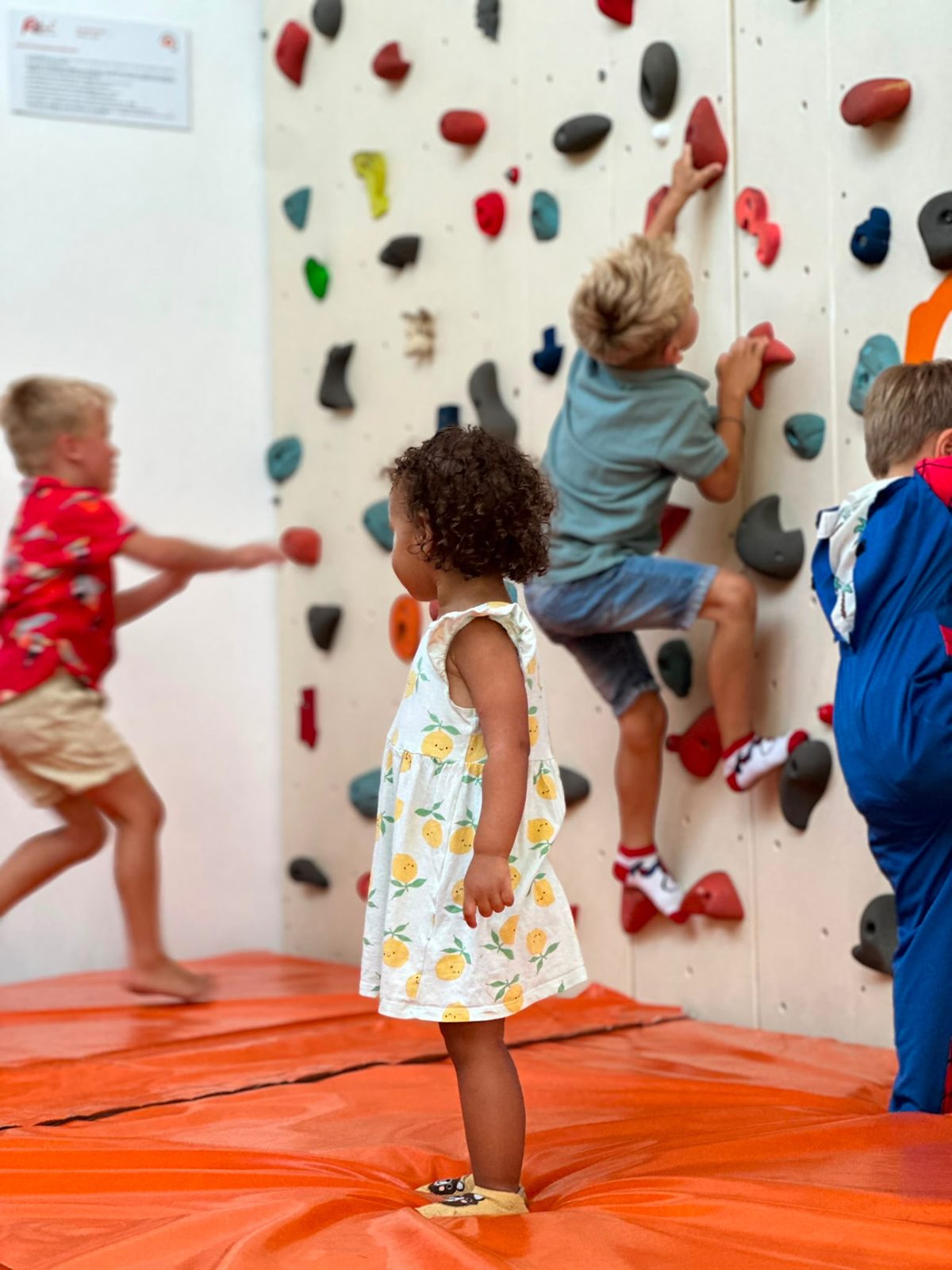 Child climbing the indoor climbing wall at Dream Park