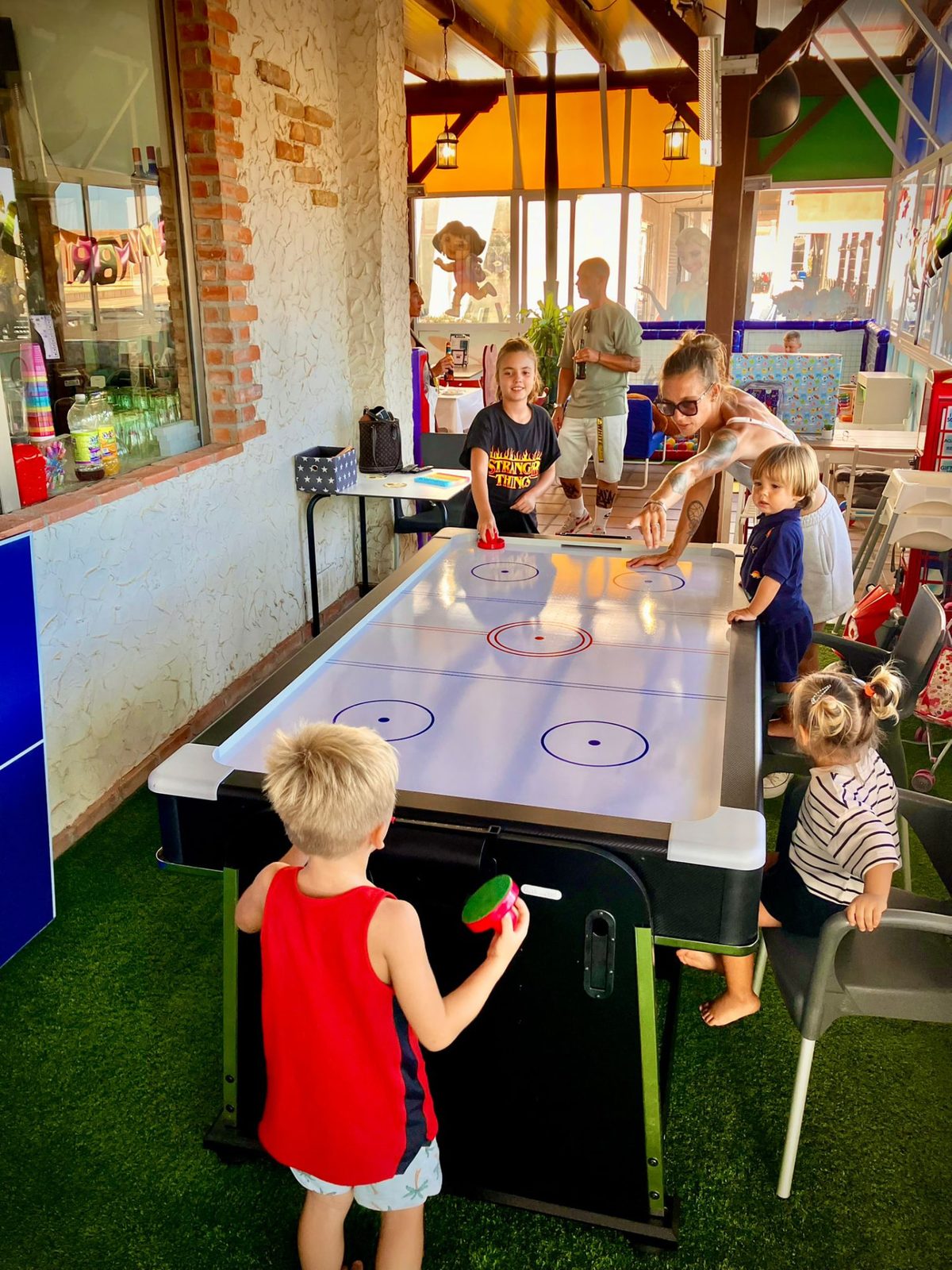 Children and adults playing air hockey at Dream Park